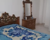 تخت خواب با روتختی آبی رنگ و میز آرایش اتاق خواب شهرک نیایش