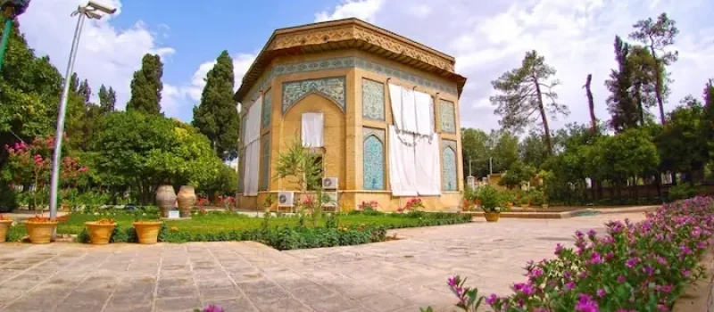 نمای بیرونی ساختمان آجری قدیمی به همراه محوطه سازی و گل آرایی در باغ نظر شیراز 498758945