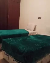 دو تخت خواب با روتختی سبز رنگ و کمد دیواری اتاق خواب ویلا در شهرک نیایش
